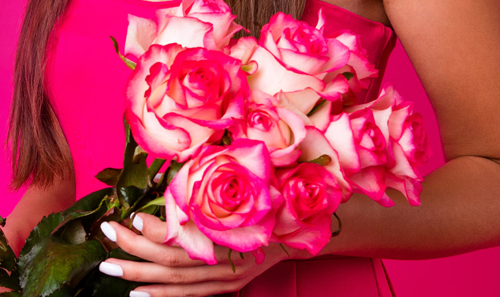 Woman Holding a Bouquet of Pink Roses - Tunie's Floral Expressions Logo